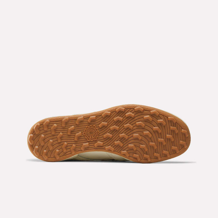 Bottom view of the Reebok x Manors Club C Revenge Golf Shoes, showcasing a textured brown rubber sole with a geometric star pattern at the center and varied tread design for enhanced traction, reflecting the signature attention to detail from both Reebok and Manors.