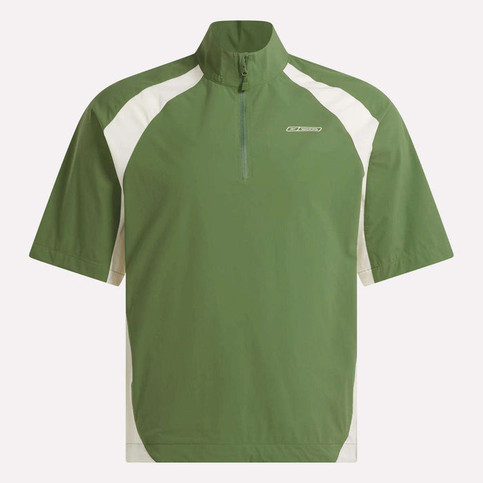 The Reebok x Manors Men’s Tour Shirt is a green, short-sleeved golf pullover featuring a half-zip front, high collar, and white panels on the shoulders and sides. This men’s shirt from Reebok’s collaboration with Manors displays a small logo on the left chest.