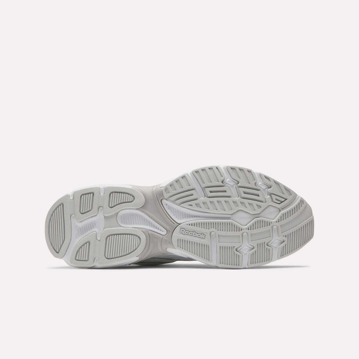The image displays the gray, textured rubber sole of Reebok Road Prime Shoes against a white background, featuring varied tread patterns and the Reebok logo near the center, reflecting classic Y2K running style.