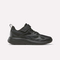 The Reebok Rush Runner 6.0 Elastic Lace Top Strap Running Shoes for little kids in Black/Black/Black feature a mesh and synthetic upper, hook-and-loop strap, and textured rubber sole for all-day comfort, shown in side profile on a white background.