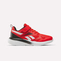 The Reebok Rush Runner 6.0 Elastic Lace Top Strap Running Shoes for little kids come in Rival Red with black and Ftwr White accents, featuring elastic red laces, a red Velcro strap, and white side stripes—ideal for young athletes.