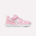 The Reebok Rush Runner 6.0 Elastic Lace Top Strap Running Shoes for little kids in Expressive Pink/Ftwr White feature a mesh and synthetic upper, hook-and-loop strap, elastic laces, and a white sole, shown in side profile on a white background.