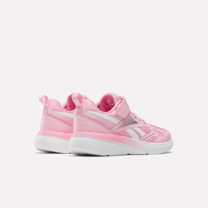 The Reebok Rush Runner 6.0 Elastic Lace Top Strap Running Shoes for little kids feature pink and white design, white soles, Velcro straps, and logo detailing—ideal for young runners seeking style and comfort.
