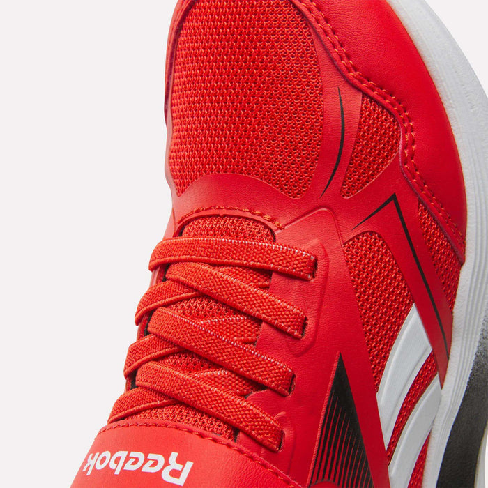 Close-up of Reebok Rush Runner 6.0 Elastic Lace Top Strap Running Shoes for little kids, featuring red mesh and synthetic materials, red laces, white and black side details, and a partially visible Reebok logo near the toe.