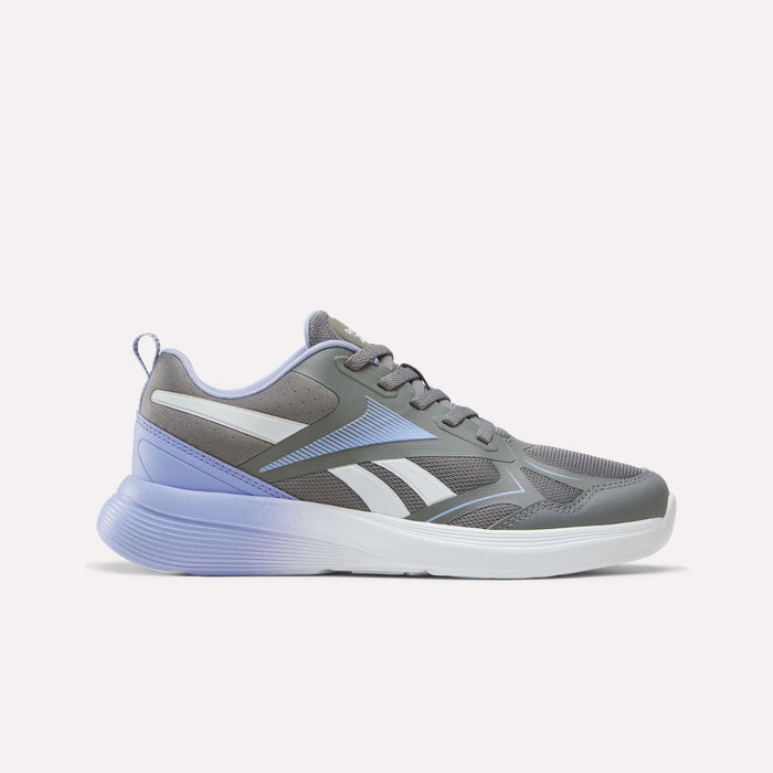 The Reebok Rush Runner 6.0 Running Shoes for Big Kids, shown in Grey 4/Lilac Glow/Ftwr White, feature a sporty design with mesh panels, white accents, light blue details, and a thick white and purple sole with a cushioned EVA midsole. They are displayed on a plain white background.