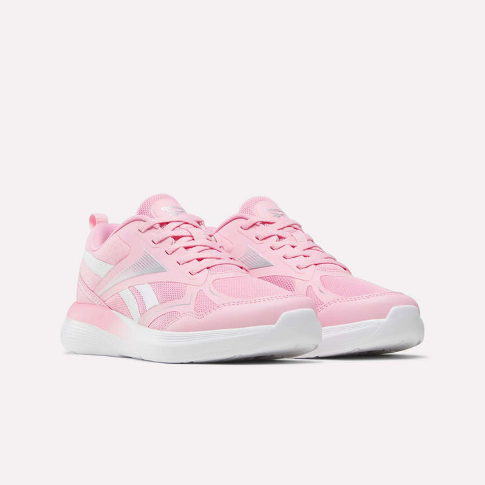 The Reebok Rush Runner 6.0 Running Shoes for big kids are light pink with white accents and durable white soles, featuring a comfortable EVA midsole, shown on a plain white background.
