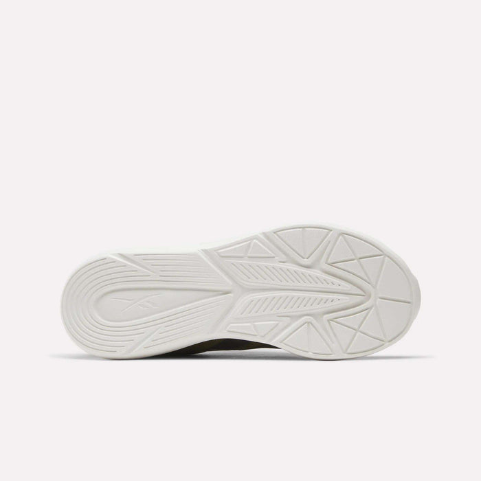 The image displays the white outsole of the Reebok Rush Runner 6.0 Running Shoes for Big Kids, featuring a geometric tread pattern with grooves and textured lines to enhance grip. This model includes an EVA midsole for increased comfort and support, and is photographed against a plain, light background.