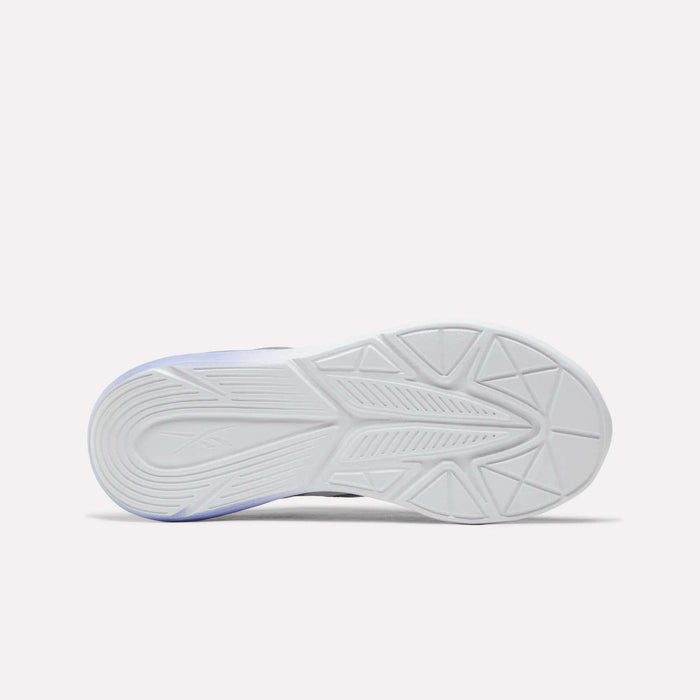 The image displays the white rubber outsole of the Reebok Rush Runner 6.0 Running Shoes for big kids, viewed from beneath and showcasing geometric tread patterns and textured details engineered for grip. The athletic shoe also includes an EVA midsole to provide enhanced comfort and support.
