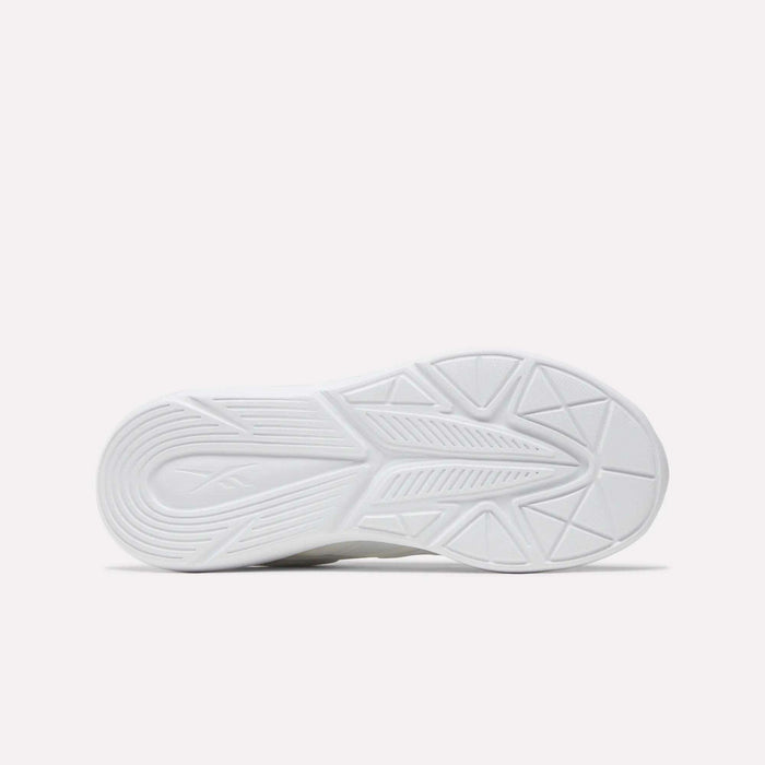The image shows the sole of Reebok Rush Runner 6.0 Running Shoes for big kids, featuring a geometric tread pattern with curved lines and triangles on a plain white background. The design likely includes an EVA midsole for comfort.