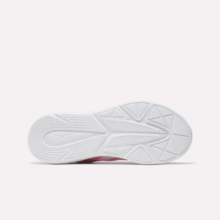 The image shows the bottom view of Reebok Rush Runner 6.0 Running Shoes for big kids, featuring a white rubber sole with a geometric tread pattern for traction. The plain light background highlights typical details of Reebok running shoes.