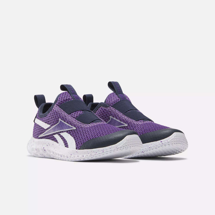 A pair of Reebok Rush Runner Slip-On Shoes for little kids in purple, featuring white soles, black toe caps, and white and purple logos on the sides, displayed on a light background.