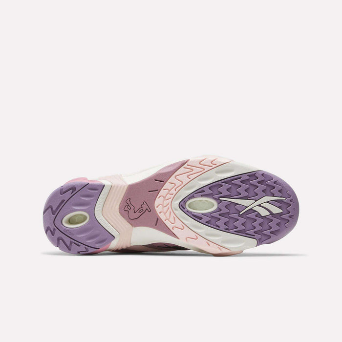 The image shows the sole of the Reebok Shaqnosis Low Shoes, featuring purple, pink, and off-white colors with textured patterns, Hexalite cushioning details, and a visible Reebok logo on the right side.