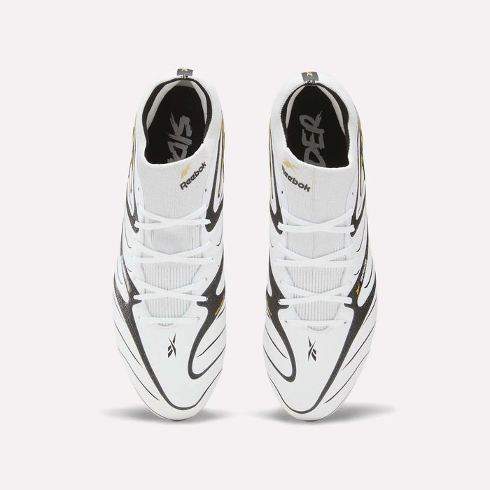 Top view of a pair of Reebok Sidewinder 26 Elite Firm Ground Cleats in white with black and gold accents, featuring crisscrossed designs and Reebok logos on the tongues and sides, set against a plain light background—perfect for ball control on firm grass.