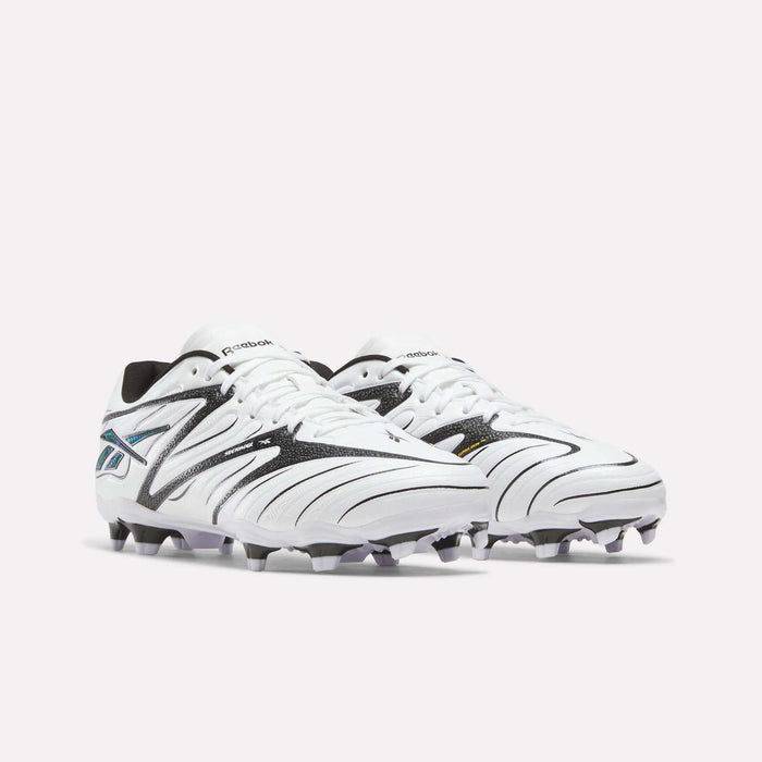 A pair of Reebok Sidewinder 26 League Firm Ground Cleats for big kids, in white with black and silver accents and designed with firm ground studs, are placed side by side on a plain light background.