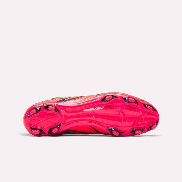 The Reebok Sidewinder 26 League Firm Ground Cleats are showcased from the sole, highlighting their bright pink and black design, textured grip pattern, and specialized firm ground studs engineered for optimal traction and superior ball control on the field.