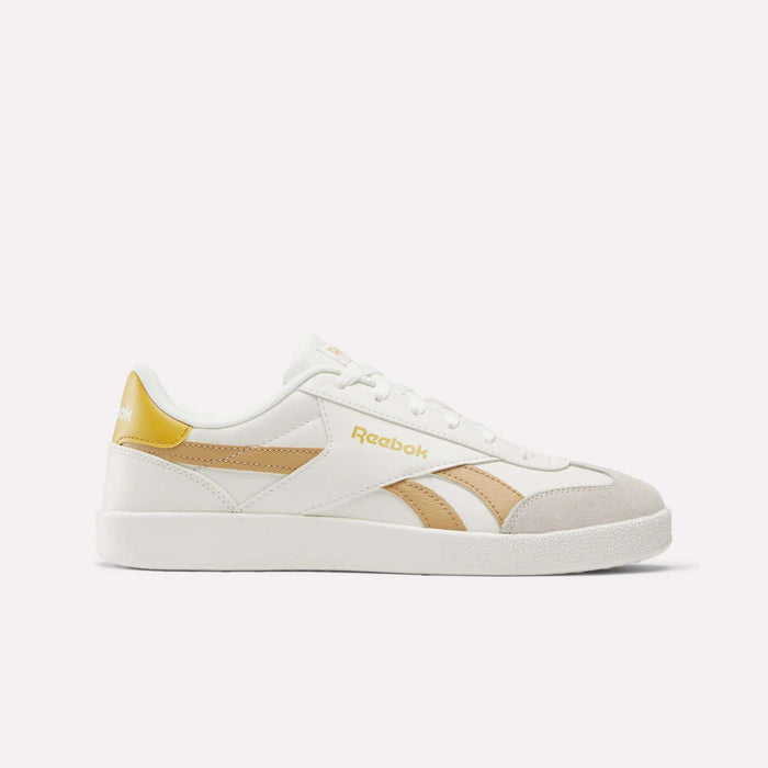 The Reebok Smash Edge Shoes feature a white design with beige and gold accents and the Reebok logo on the side and heel—ideal for fans of classic indoor soccer style, shown against a plain white background.