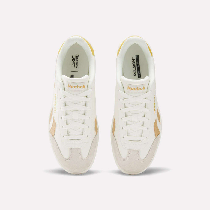 Top view of Reebok Smash Edge Shoes in white with beige details, displaying the Reebok logo on tongue and side, set against a plain light background. Ideal for those seeking stylish and comfortable indoor soccer footwear.