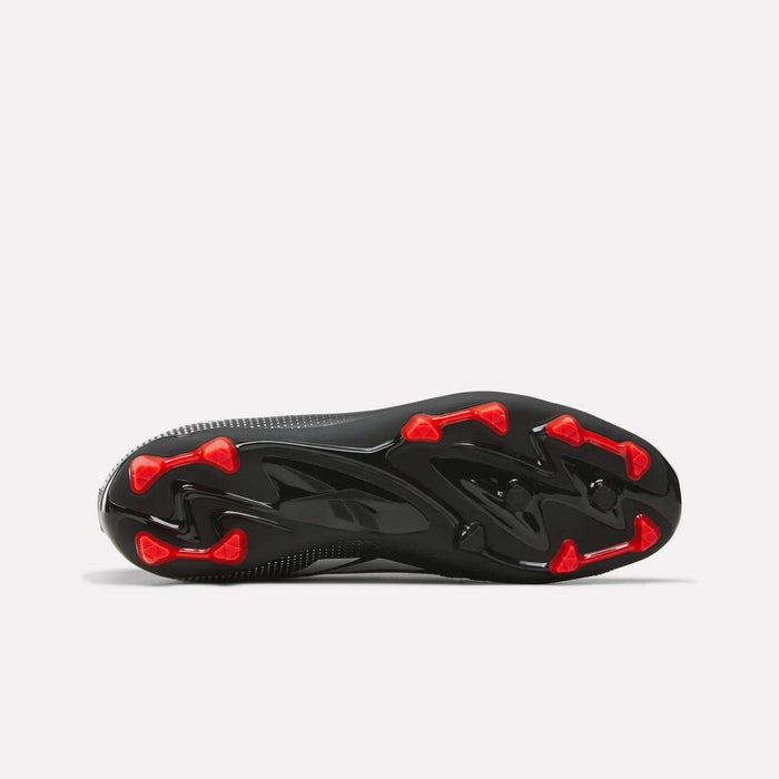 The image displays the black outsole of Reebok Strike Multi Ground Soccer Cleats, featuring red triangular studs positioned for traction. The background is plain white.