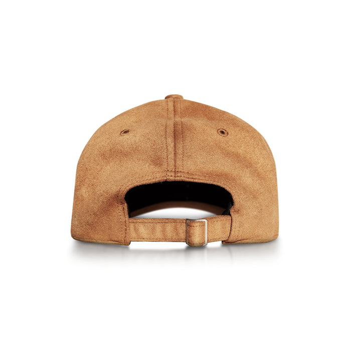 The Reebok Suede Badge Cap in brown vegan suede is shown from the back, highlighting its adjustable strap with a metal buckle against a white background.