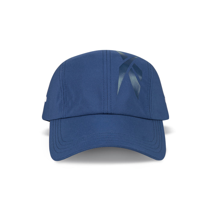 The Reebok Technical Running Cap With Drawcord is shown front-facing, featuring a dark blue ribbon-like graphic, visible stitching on brim and crown, and made from recycled materials for eco-friendly performance.