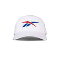 The Reebok Vector Baseball Cap, shown from the front against a white background, features a red and blue stylized logo on its white design.