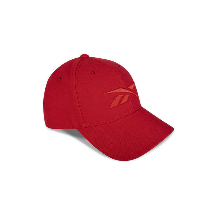 A Reebok Vector Baseball Cap in red, featuring an embroidered logo on the front left panel and an adjustable snapback closure, is displayed against a white background.
