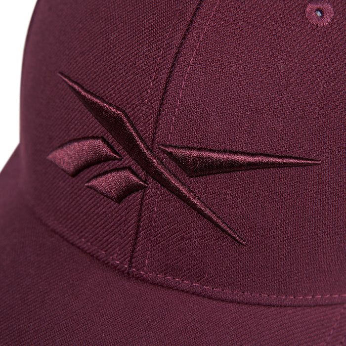 Close-up of the Reebok Vector Baseball Cap in maroon, featuring a maroon embroidered Reebok logo on the front.