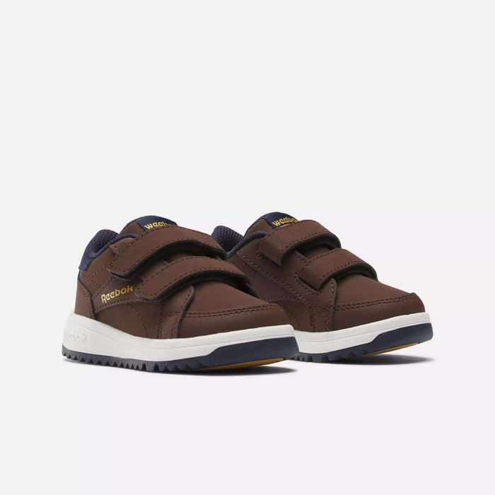 The Reebok Weebok Clasp Low Shoes for infants and toddlers feature brown uppers, navy blue accents, white soles, and two Velcro straps, offering comfort for little ones; shown on a plain white background.