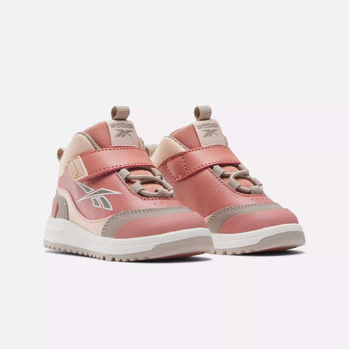 A pair of Reebok Weebok Storm X Shoes for infants and toddlers in pink and beige, featuring hook-and-loop straps and white soles, displayed on a white background.