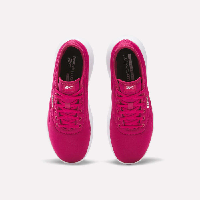 A pair of Women's Active Lite Shoes by Reebok in bright pink, seen from above with white soles, pink laces, and “Reebok” logos on the tongue and side. These minimalist sneakers are side by side on a plain white background.