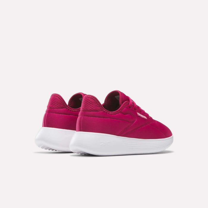 A pair of Women's Active Lite Shoes by Reebok in bright pink with white soles, featuring DMX technology, shown from the back and side against a plain light background.