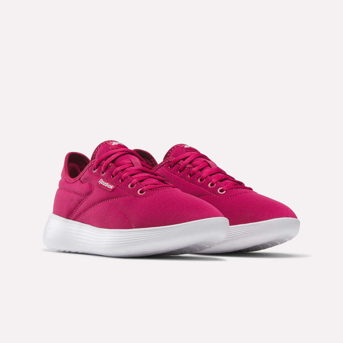 A pair of Women's Active Lite Shoes by Reebok in bright pink with white soles, featuring laces and a simple, modern design, shown at an angle on a plain light background.
