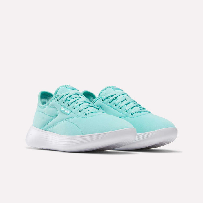 The Reebok Women's Active Lite Shoes, shown in teal with white soles on a plain white background, feature DMX technology for comfort, a sleek modern design, minimal branding, and a minimalist aesthetic.