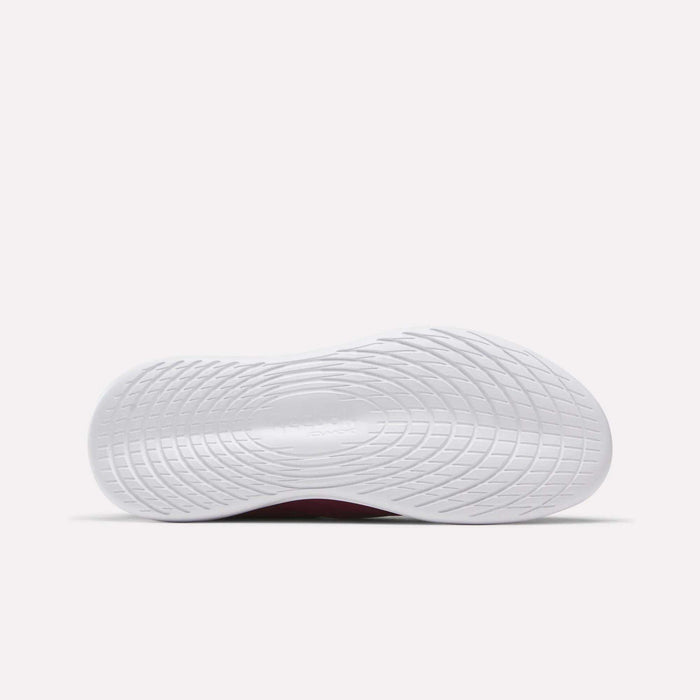 The image displays the bottom view of a Women's Active Lite Shoe by Reebok, highlighting a textured, wavy sole designed for traction. The background is plain and light-colored.
