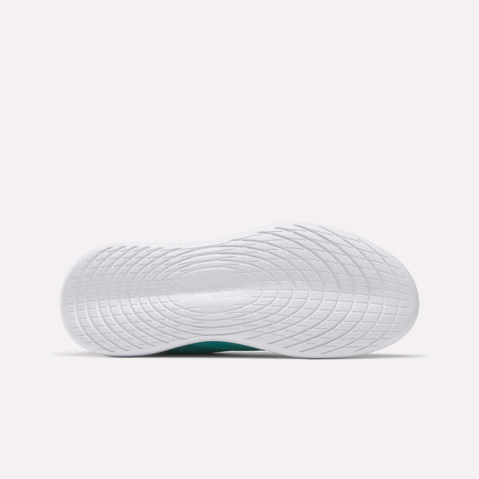 The image displays the white sole of Reebok Women's Active Lite Shoes from below. The minimalist sole has a curved, textured pattern for grip and support, set against a plain, light-colored background.
