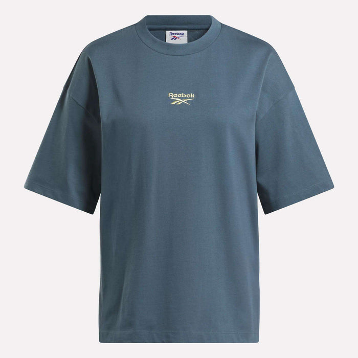 The Reebok Women's Boxy T-Shirt is a plain blue, short-sleeve cotton jersey tee with a small white Reebok logo on the chest, shown against a white background.