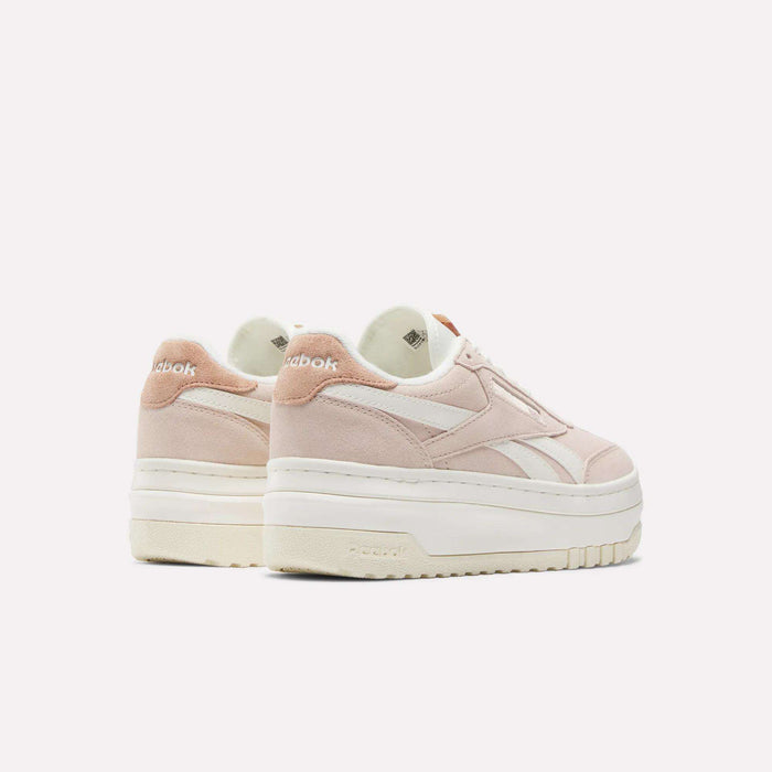 A pair of Reebok Women's Campio Extra Shoes, featuring pale pink suede with white accents, thick white soles, and Reebok logos on the heel and side, displayed against a plain light background.
