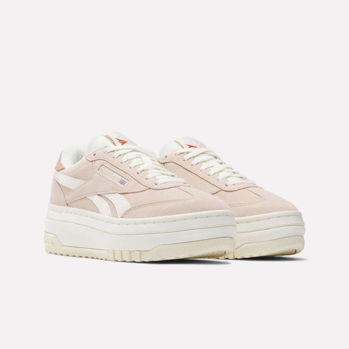 A pair of Reebok Women's Campio Extra Shoes in light pink suede with white laces, thick off-white soles, and classic side stripes, displayed against a plain light background.