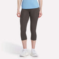 A woman models Reebok Women's Capri Leggings, shown from the waist down against a plain white background.