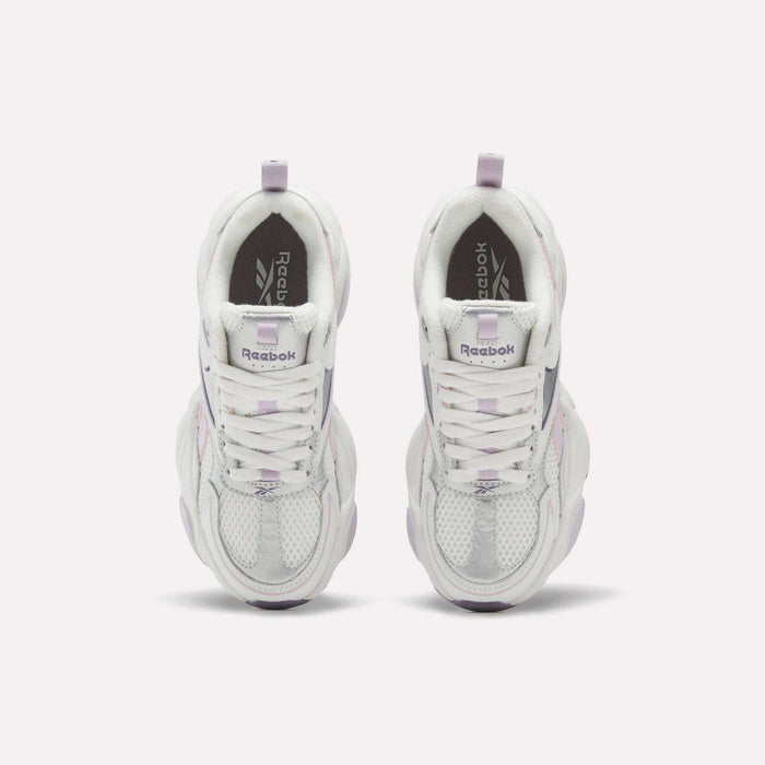 A pair of Women’s Charge Shoes by Reebok in white and lavender, viewed from above, displaying mesh-textured toes, lace-up fronts, and Reebok branding on the tongues and insoles—the perfect training shoes for your next workout.