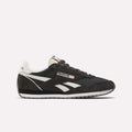 The Reebok Women's Classic AZ Shoes feature black and white suede and leather details, signature white side stripes, a black sole, and the Reebok logo on the side and tongue—all shown against a plain white background.