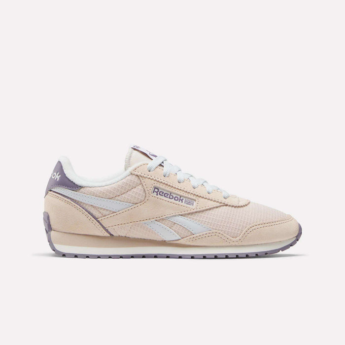 The Reebok Women's Classic AZ Shoes in beige feature light blue stripes and laces, a white midsole, and lavender outsole and heel details. These 70s-inspired sneakers are pictured from the side on a plain white background.
