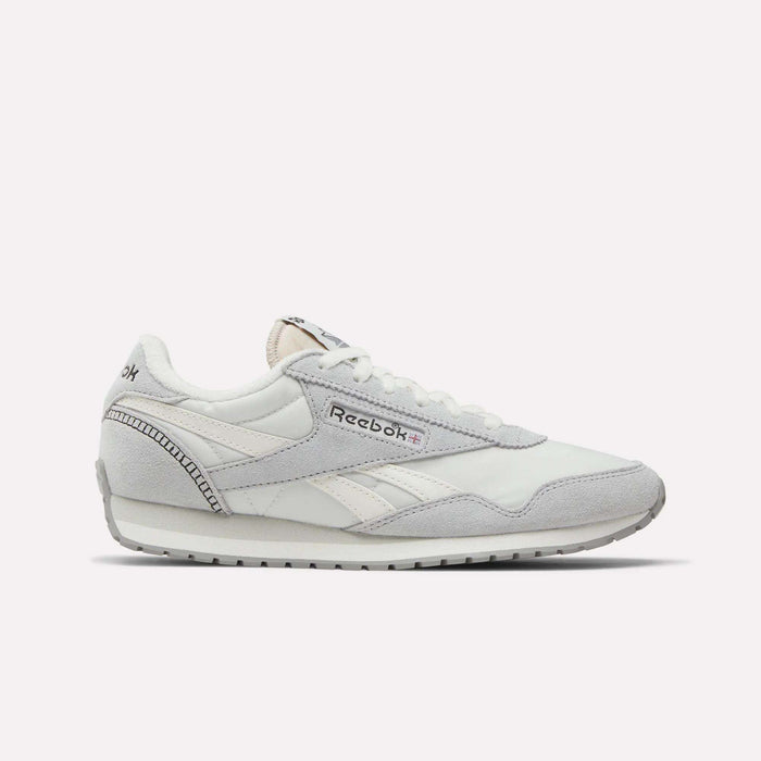 The Reebok Women's Classic AZ Shoes are white sneakers with grey accents, light grey suede details, and the Reebok logo on the side. These lace-up runners offer a low-profile silhouette and flat rubber sole for everyday comfort.