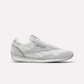 The Reebok Women's Classic AZ Shoes are white sneakers with grey accents, light grey suede details, and the Reebok logo on the side. These lace-up runners offer a low-profile silhouette and flat rubber sole for everyday comfort.