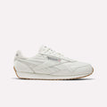 A Reebok Women's Classic AZ Shoe in Chalk/Chalk/Gum features a leather upper, gum sole, side branding, and stitched details—shown from a side view against a plain light background—capturing the enduring style of Reebok women's footwear.