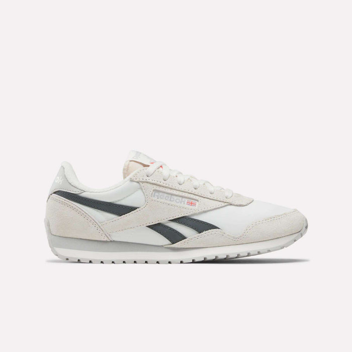 Side view of Reebok Women's Classic AZ Shoes in white with light gray suede accents, black stripes, flat rubber sole, plus Reebok logo and small Union Jack on the side.
