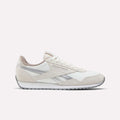 The Reebok Women's Classic AZ Shoes feature a white and beige colorway with silver accents, vintage details, low-top design, lace-up closure, and rubber sole—making them a stylish addition to any women’s sneaker collection. Shown on a white background.