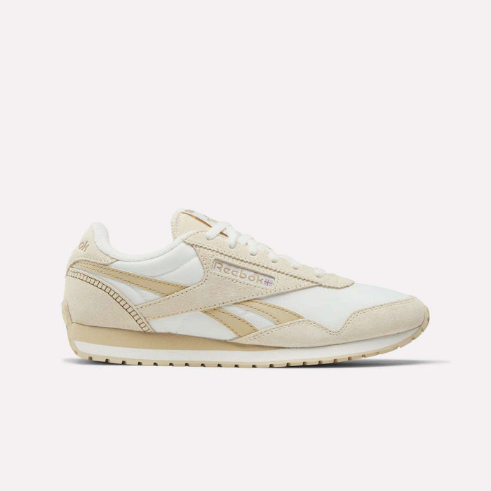 The image shows Reebok Women's Classic AZ Shoes in white and beige nylon with suede accents, white laces, and the Reebok logo plus a British flag on the side. These low-profile sneakers are displayed against a plain white background.