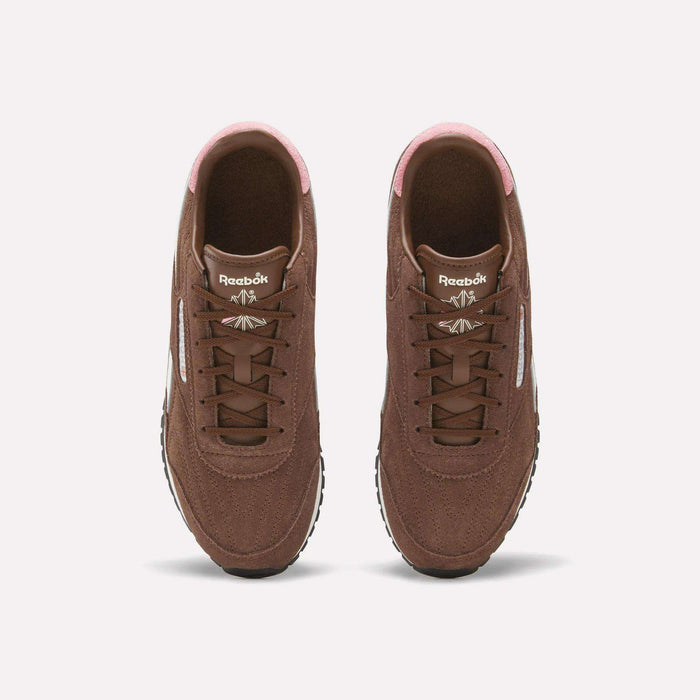A pair of Women’s Classic AZ Shoes by Reebok in brown with pink accents is shown from above, highlighting the laces, tongue logo, and white side stripes—these vintage sneakers make a stylish addition to any women’s running shoe collection.