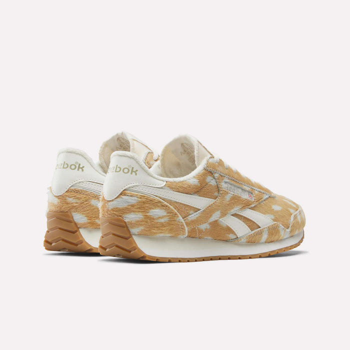 The Women's Classic AZ Shoes by Reebok feature a tan and white faux fur upper with a spotted animal print, white accents, gum rubber soles, and classic branding—ideal for fans of retro style and vintage sneakers.